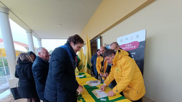 Francesco Menna mentre appone la firma