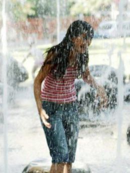 Nella foto, una ragazza nelle acque di una fontana
