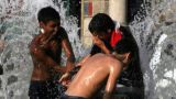 Nella foto, ragazzi giocano in una fontana